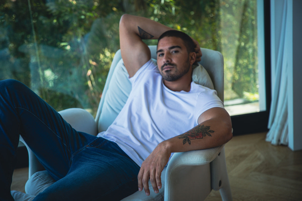 Man relaxing in a white tee and dark jeans