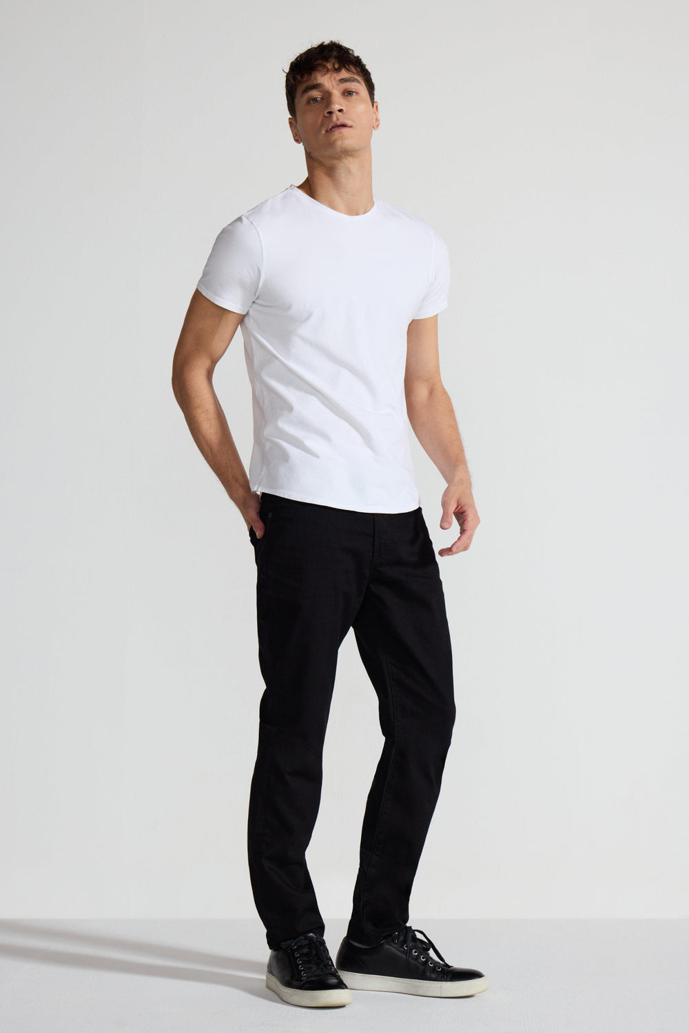 Model wearing MONFRÈRE Brando Noir men's black Japanese stretch denim five pocket slim jean.