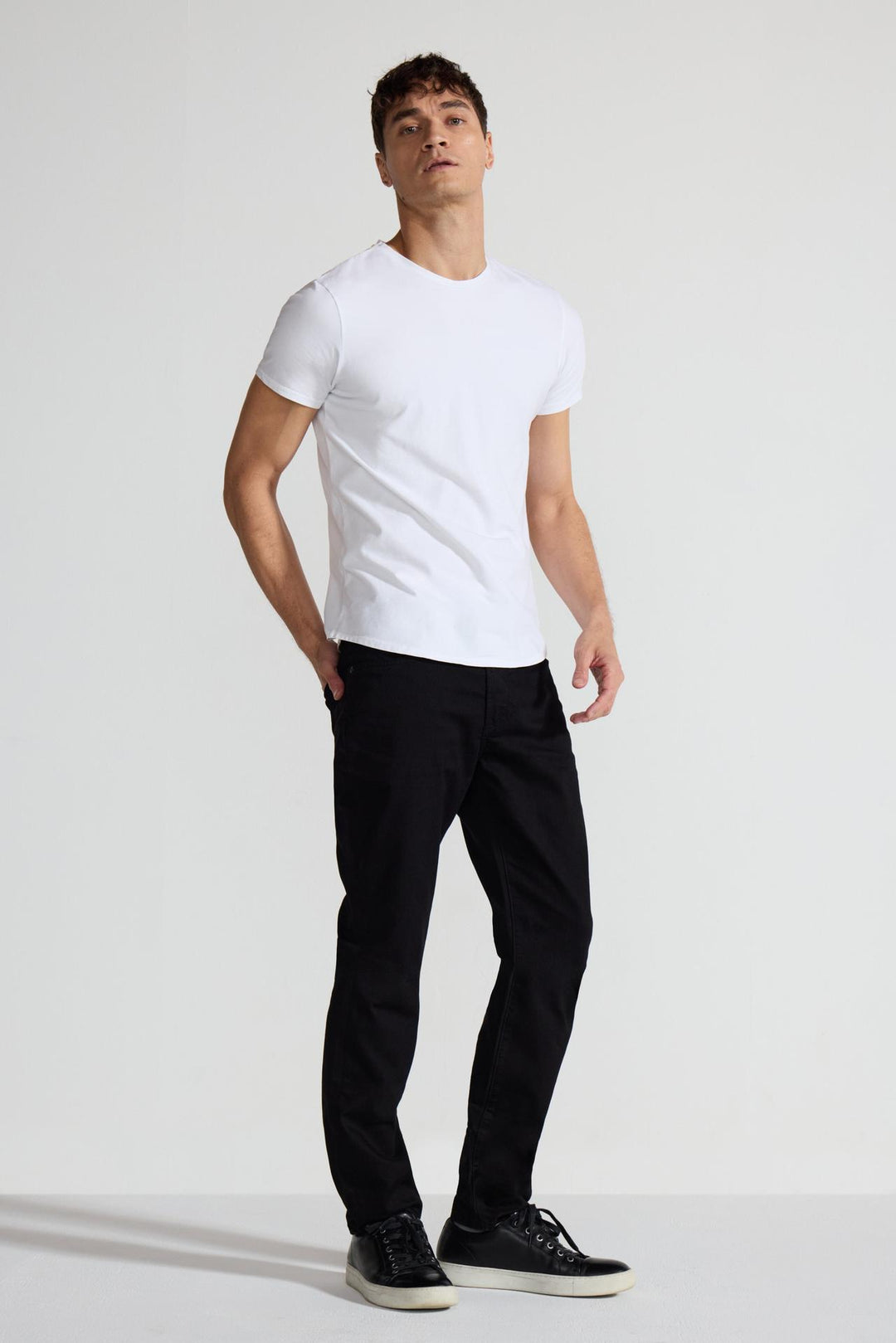 Model wearing MONFRÈRE Brando Noir men's black Japanese stretch denim five pocket slim jean.