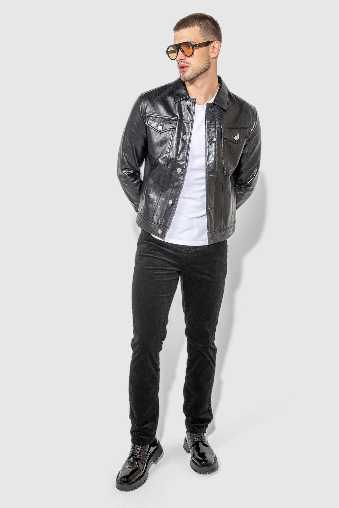 Model wearing MONFRÈRE Dean Patent Noir men's black stretch vegan leather trucker jacket.