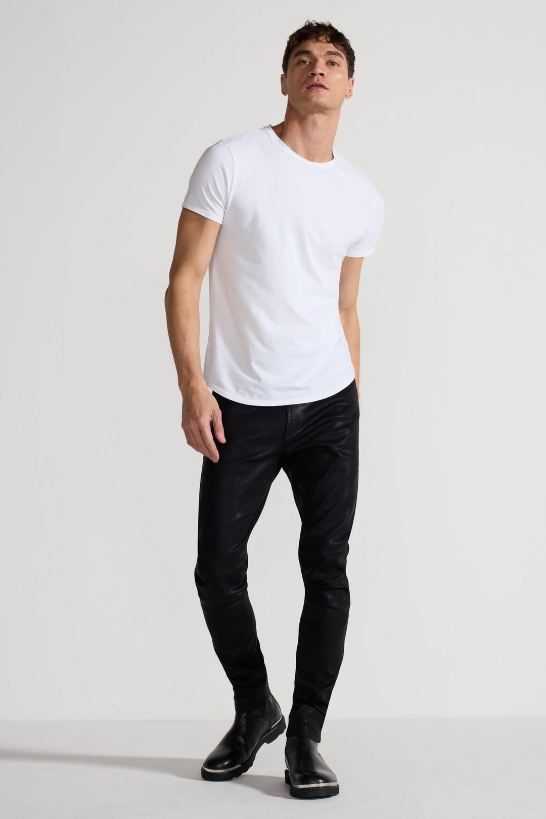 Model wearing MONFRÈRE Greyson Coated Noir men's black coated Japanese stretch denim five pocket skinny jean.