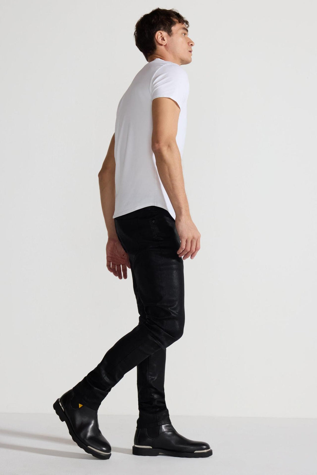 Side profile of MONFRÈRE Greyson Coated Noir men's black coated Japanese stretch denim five pocket skinny jean.
