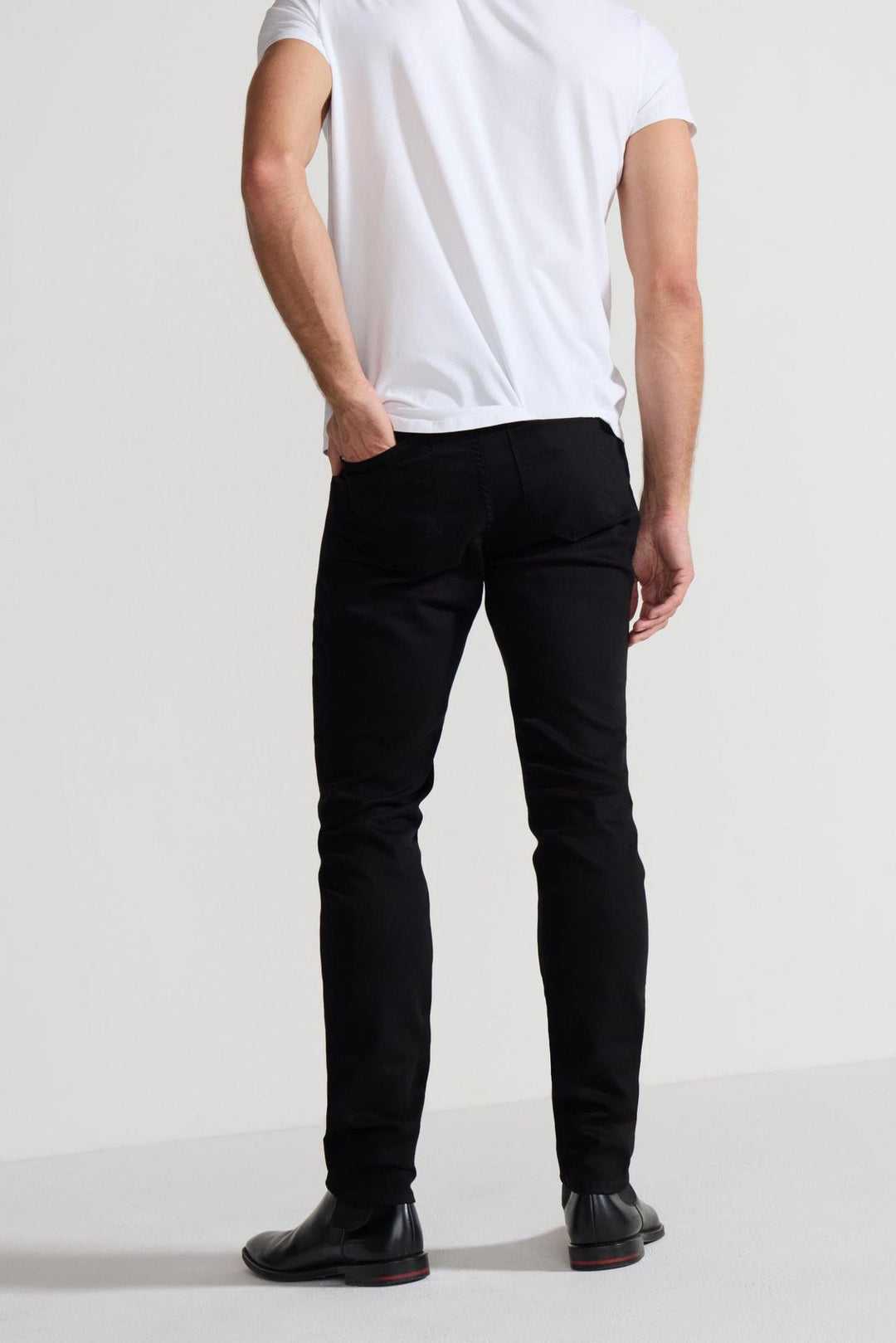 Back profile of MONFRÈRE Greyson Noir men's black Japanese stretch denim five pocket skinny jean.