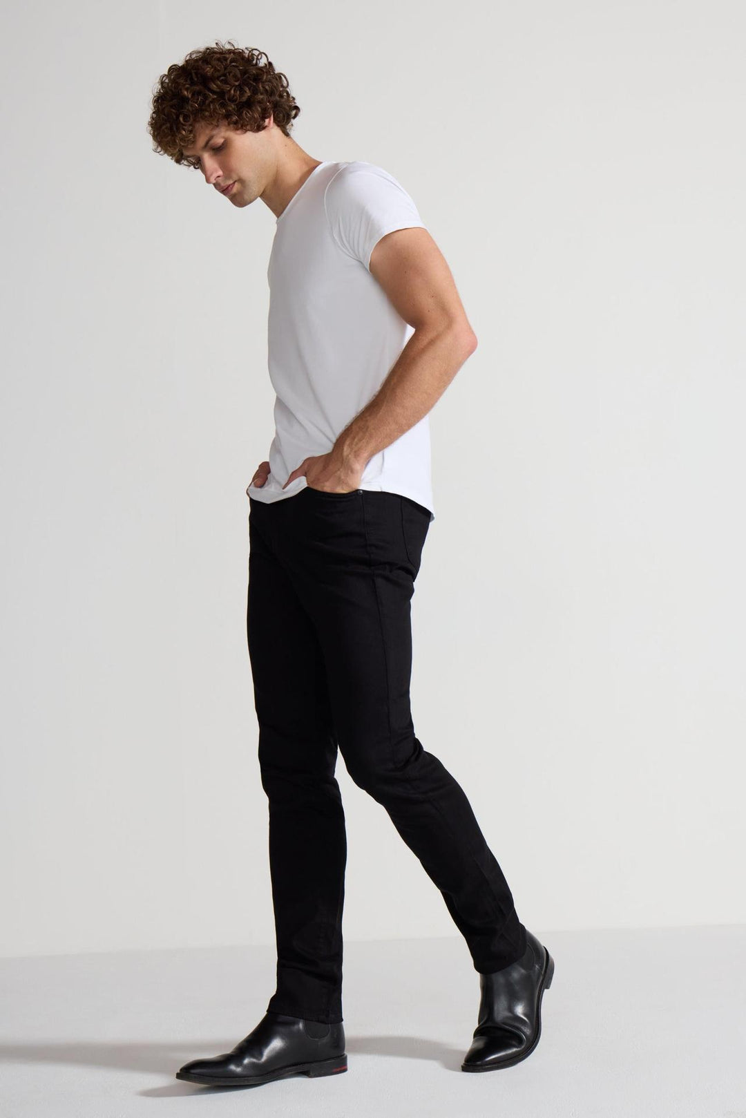 Side profile of MONFRÈRE Greyson Noir men's black Japanese stretch denim five pocket skinny jean.