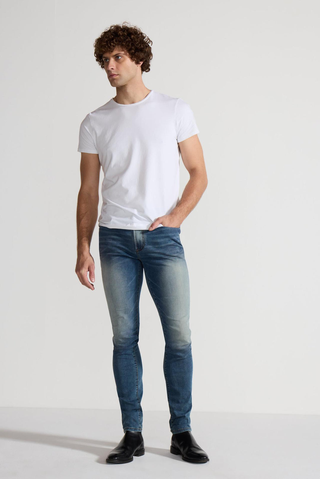 Model wearing MONFRÈRE Greyson Tinted Indigo men's dark blue Japanese stretch denim five pocket skinny jean.