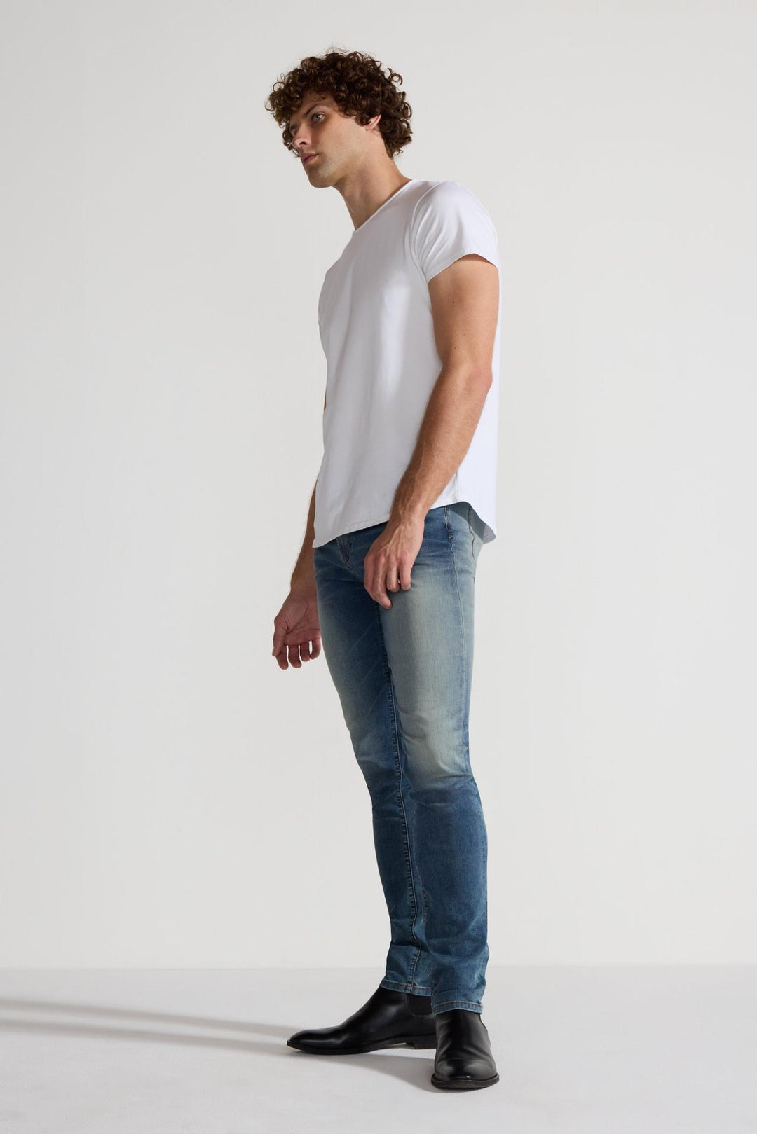 Side profile of MONFRÈRE Greyson Tinted Indigo men's dark blue Japanese stretch denim five pocket skinny jean.