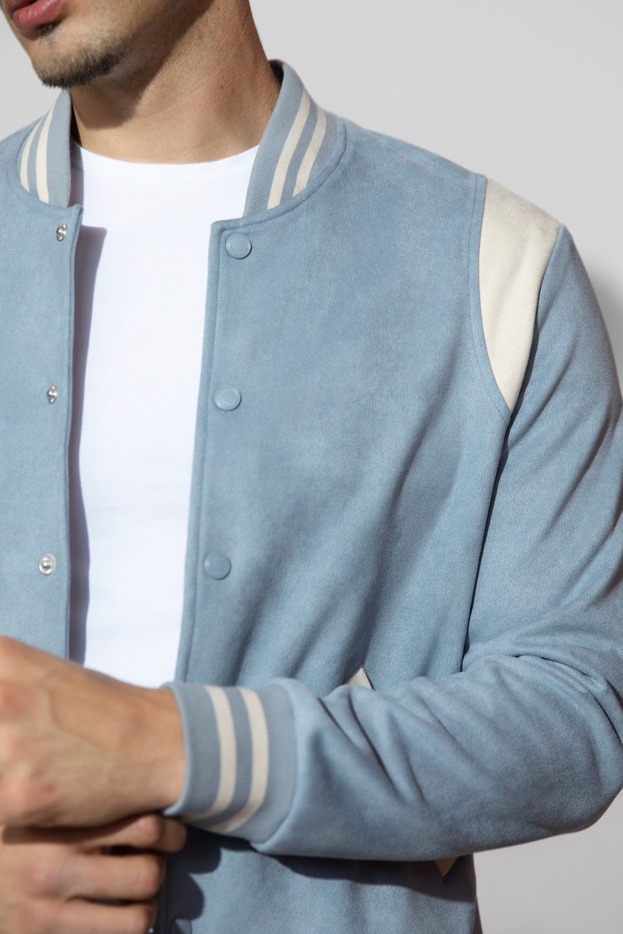 Detail view of MONFRÈRE Jeter Varsity Suede Carolina men's blue soft faux suede stretch fabric varsity jacket.