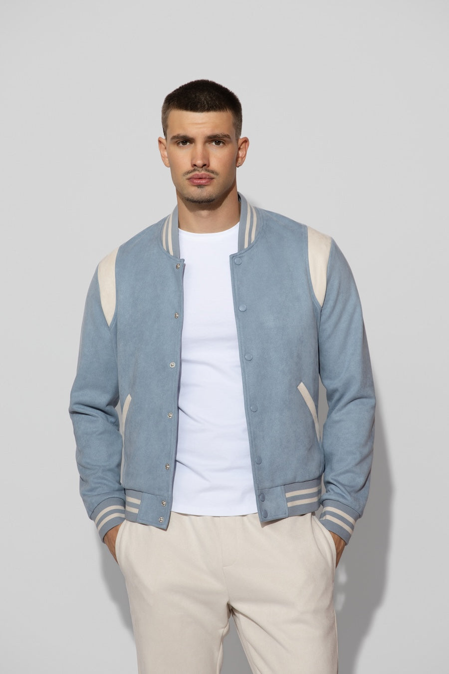 Front profile of MONFRÈRE Jeter Varsity Suede Carolina men's blue soft faux suede stretch fabric varsity jacket.
