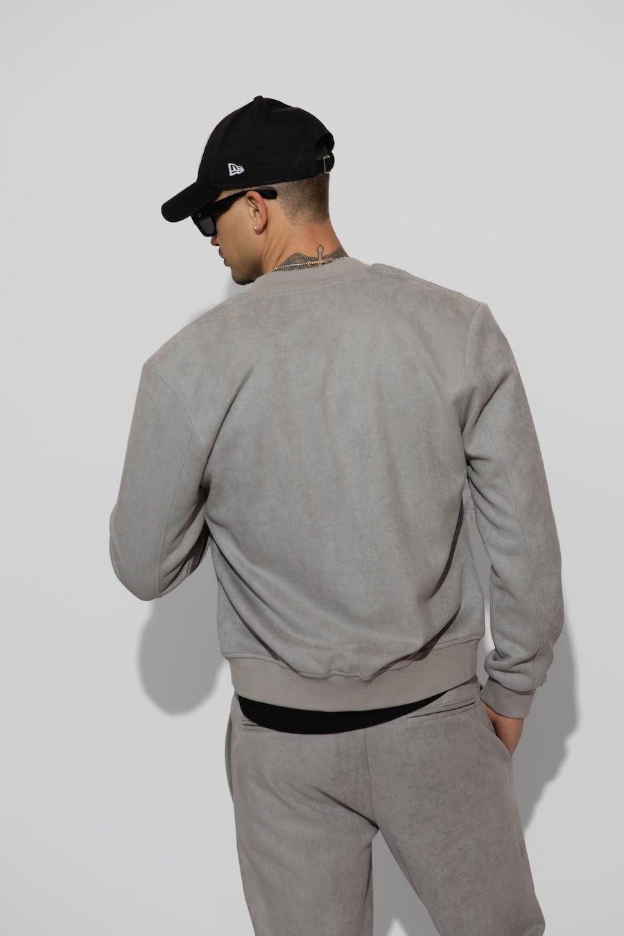 Back profile of MONFRÈRE Maverick Butter Suede Cool Grey men's light grey soft faux suede stretch fabric bomber jacket.