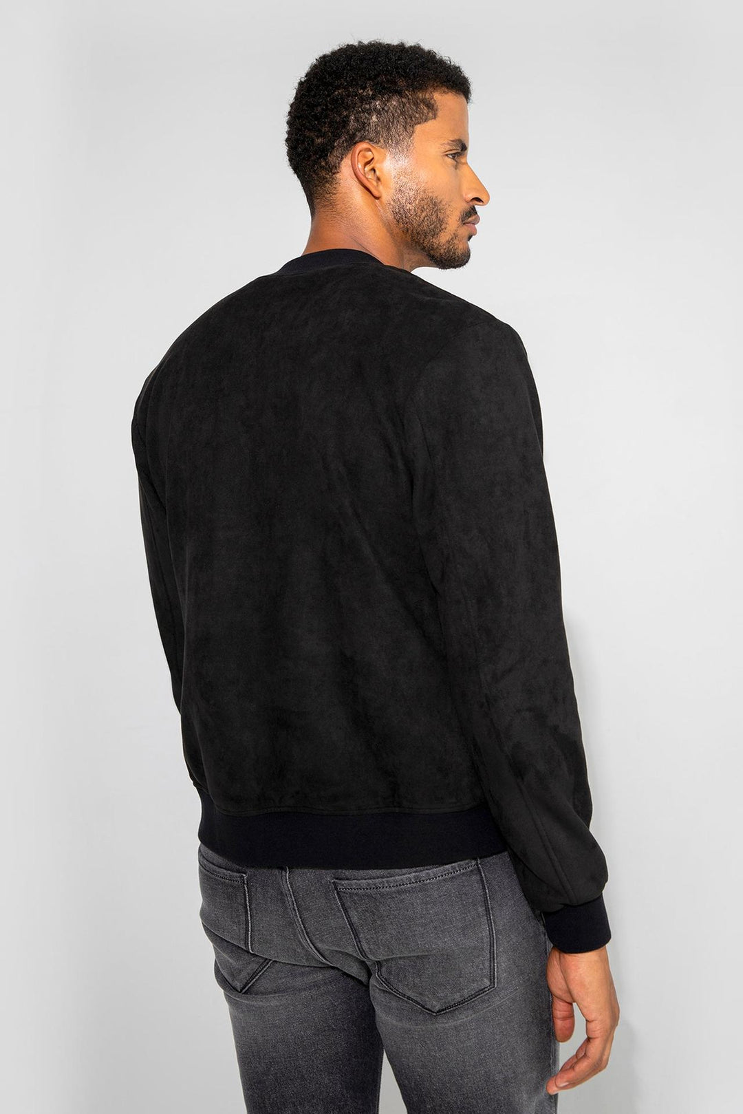 Back profile of MONFRÈRE Maverick Butter Suede Noir men's black soft faux suede stretch fabric bomber jacket.