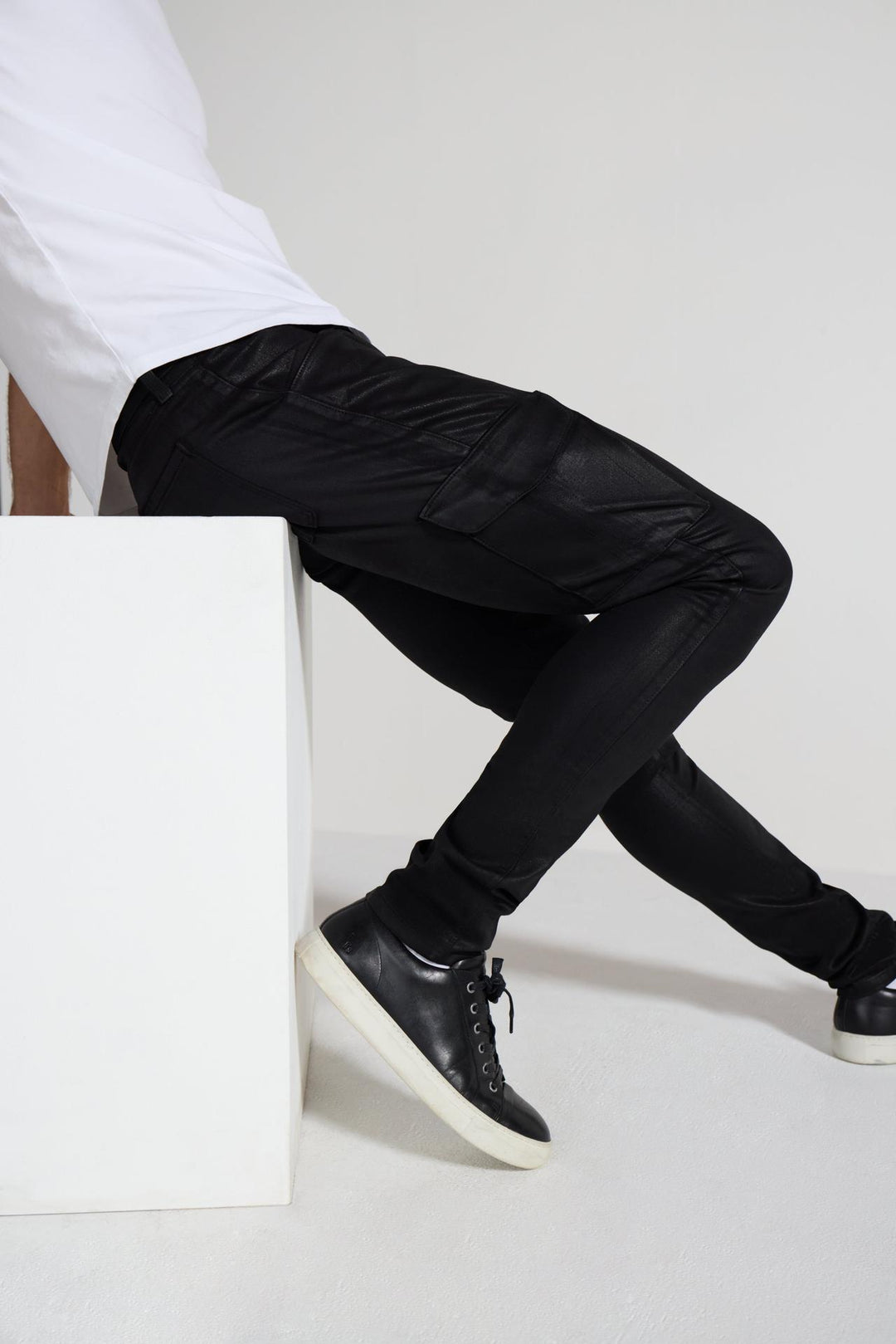 Detail view of MONFRÈRE Preston Coated Noir men's black coated stretch sateen tencel twill skinny cargo pants.